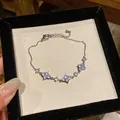 Primo piano di un bracciale in argento scintillante con tre fiori di zirconi - Stile 1