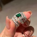 Detail view of an ornate silver hollow ring featuring an emerald green rectangular zircon. - New Chinese Hollow Style (HR2288) / Adjustable Open / Silver/Emerald Green