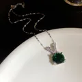 Vue détaillée du collier pendentif V en argent avec pierre verte facettée et zircons - Blanc