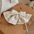 Detail van bloemenstoffen haarklem met witte kanten rand en lange linten. - Veerclips / Wit