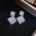 Dettaglio di orecchini a rombo in zircone scintillante con perni in argento. - Rombo (HE32086) / Argento