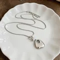 Close-up view of a silver geometric smooth pendant necklace with clear and white beads - Necklace - Silver