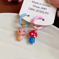 Detailed close-up of asymmetrical glass mushroom hoop earrings with vibrant enamel finish. - Asymmetric Mushroom Style (HE31778) / Colorful