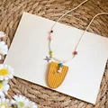 Primer plano de un collar de cuentas coloridas con dijes de estrella de mar y colgante amarillo. - Amarillo