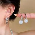 Elegant silver bow and large pearl hoop earrings set, perfect for stylish women. - Bowknot And Pearl Earring Set