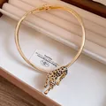 Detailed close-up of a luxury gold leopard choker necklace with black enamel spots - Gold Choker With Black Leopard Print