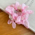 Close-up detail of a pink chiffon flower hair tie accented with decorative white pearls - Vacation Style Pearl Chiffon Flower / Pink