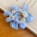 Close-up of a blue chiffon flower hair tie with white pearl center for elegant hair styling - Vacation Style Pearl Chiffon Flower / Blue