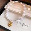 Elegant baroque pearl necklace with gold heart pendant in a jewelry display box - White