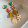 Detailed view of vintage resin drop earrings with colorful geometric stones. - Gold
