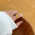 Close-up detail of a minimalist gold-plated ring with yellow resin and small pearls - Open Ring / Gold