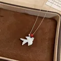 Macro view of elegant white shell swallow pendant necklace with red bead detail - Swallow Shell Pendant Clavicle Chain / Silver