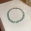 Nahaufnahme eines eleganten Armbands mit smaragdgrünen Steinen und Akzenten - Rechteckiger Smaragd-Blumenstil (54#)