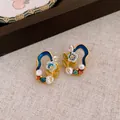 Detailed macro shot of vintage Monet garden style stud earrings with enamel and pearls - Silver Post-Gold Blue / Gold