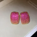 Macro view of vintage gold C-shaped earrings fully paved with pink cubic zirconia stones - Pink