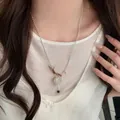 Close-up of a stylish silver beaded heart necklace worn by a female model in white - Vintage Silk Decor Heart Style / Silver