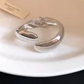 Detailed view of a silver minimalist twisted droplet bangle with a polished finish. - Silver
