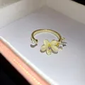 Primo piano di un elegante anello aperto in oro con fiore in occhio di gatto e cristalli - Stile Fiore Aperto / Aperto Regolabile / Oro