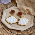 Detailed macro view showing elegant gold and white shell drop earrings for beach vacation - Scallop Shape (HE33712) / White, Coffee