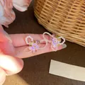 Close-up of colorful Y2K style handmade beaded earrings with purple flowers and pearls - Purple/White (Steel Post)