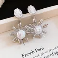 Detail shot of French retro earrings with wrinkled pearl petals and silver flower base. - Silver
