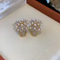 Dettaglio di eleganti orecchini a perno a cesto di fiori placcati oro 18k con perle e zirconi - Oro