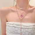 Close-up detail of a layered gold necklace with a pink cherry blossom flower pendant - Gold-Rose Red-Red