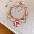 Detailed view of a gold-tone anklet with a delicate pink enamel flower pendant - Pink Flower / Gold