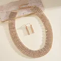 Detailed shot of gold-tone multi-row rhinestone tassel necklace and earrings set - Necklace and Earrings Set / Gold