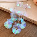 Primo piano di orecchini a nappa tondi in conchiglia iridescente con perle e aghi d'argento - Colorato
