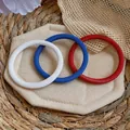 Gros plan de bracelets chaîne à ressort rouge, blanc et bleu sur un coussinet en tissu - Ensemble Bracelet Tricolore (Rouge/Blanc/Bleu)