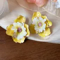 Primo piano di orecchini a lobo a fiore in tessuto giallo e bianco dalla trama elegante - Giallo-Bianco