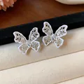 Vista dettagliata degli orecchini a farfalla in argento con smalto bianco e zirconi - Farfalla Traforata (Bianco) / Argento