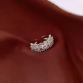 Detailed macro shot of an elegant silver tiered ring with sparkling clear rhinestones on fabric - Three-row Pave Open Ring / Style 2