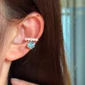 Close-up of elegant ear cuff featuring a sparkling blue hexagonal cubic zirconia pendant - Single Ear Cuff / Blue