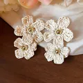 Macro detail of elegant woven raffia flower drop earrings with gold center beads - Silver Post (HE31601) / White