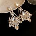 Detail shot of sparkling crystal teardrop chandelier earrings in gold-toned setting - Gold