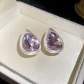 Close-up of vintage teardrop earrings with brushed silver finish and purple stones - Pink