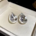 Close-up of vintage waterdrop stud earrings with brushed silver finish and faceted crystals - White