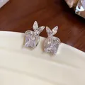 Primo piano di orecchini a lobo in argento con zircone quadrato e design a fiore - Argento