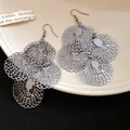 Detail view of intricate silver-tone metal hollow lace pattern dangling earrings - Gunmetal