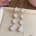 Eleganti orecchini lunghi con quattro perle barocche irregolari e montatura dorata - Oro