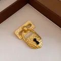 Close-up of vintage hammered gold padlock brooch with black enamel keyhole detail - Vintage Padlock Style (Gold)