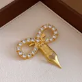 Detailed view of a vintage infinity brooch with zircons and a heart-shaped pen nib - Bow Nib Style (Gold)