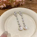 Detailed view of zircon teardrop tassel earrings with round pearls and clip-on back - Mosquito Coil Ear Clip (HE32912) / Silver/White
