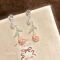 Macro view of detailed enameled rose earrings featuring zircon studs and pearls - Rose Style / Silver-Pink
