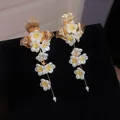 Detailed view of elegant French style white floral tassel earrings with gold leaves - Gold-White-Yellow