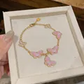 Close-up view of elegant pink enamel butterfly bracelet with sparkling zircon accents - Gold-Pink