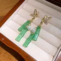 Dettaglio di orecchini di bambù con nappe in resina e strass in una confezione regalo - Nappa di Bambù (Perno in Argento 925) / Verde