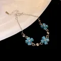 Vista dettagliata di un braccialetto a fiore in pietra occhio di gatto con strass e catena d'argento. - Bracciale a Fiore / Blu